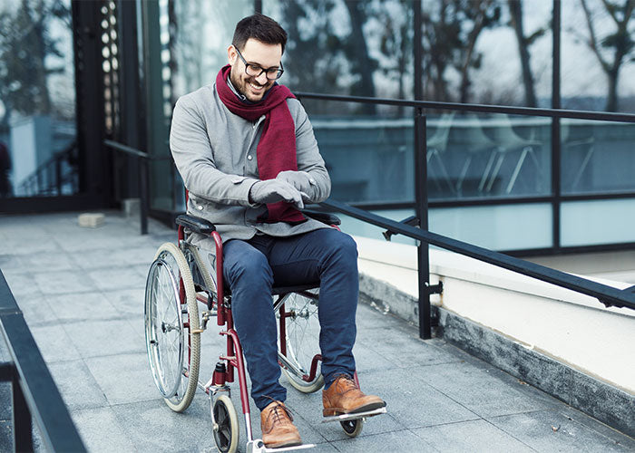 Mobility scooter and electric wheelchair side-by-side on sidewalk near a park